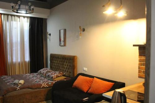 a bedroom with a bed and a couch in it at Avlabari Apartaments Nia in Tbilisi City