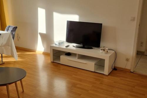 salon z telewizorem w białym centrum rozrywki w obiekcie Cosy Rent Strasbourg Garage Wifi Terrasse Dream Host Romain w Strasburgu