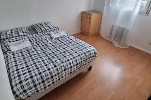 une chambre avec un lit avec une couverture à carreaux dans l'établissement Cosy Rent Strasbourg Garage Wifi Terrasse Dream Host Romain, à Strasbourg