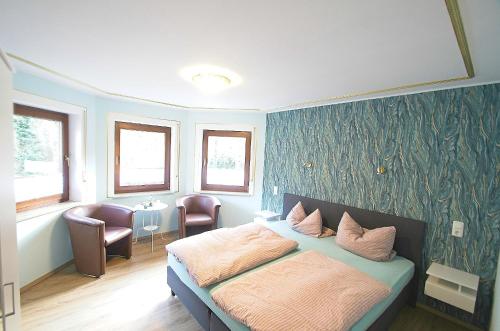 1 dormitorio con 1 cama, 2 sillas y ventanas en Pension Belzer, en Boppard