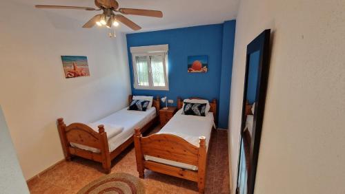 een slaapkamer met 2 bedden en een plafondventilator bij Casa Gran Mirador - Ruime vakantie villa met groot privé zwembad 8-14 pers in Alicante
