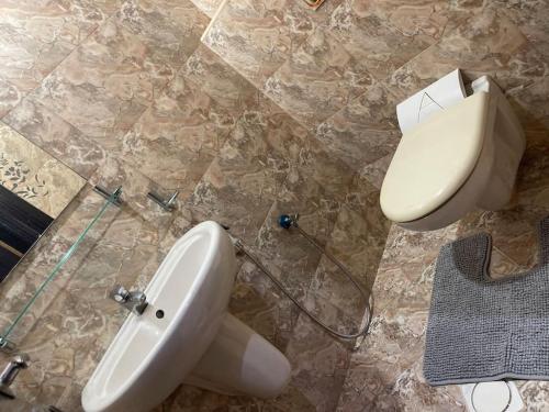 a bathroom with a white sink and a toilet at Beach view, Cozy 2BR apartment in Sharjah