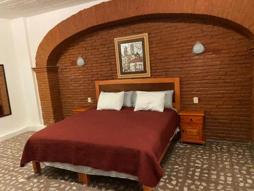 a bedroom with a large bed in a brick wall at EL GRAN TORIL in Taxco de Alarcón