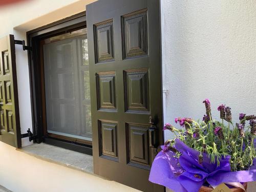 a door with a bouquet of purple flowers next to it at Pelion 7 Lives in Tsagarada