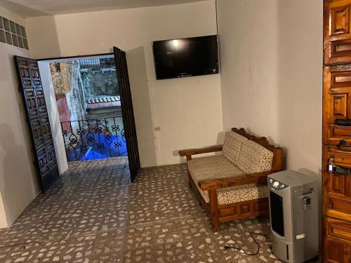 a living room with a chair and a mirror at EL GRAN TORIL in Taxco de Alarcón