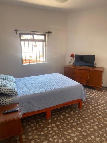 a bedroom with a bed and a television on a dresser at EL GRAN TORIL in Taxco de Alarcón