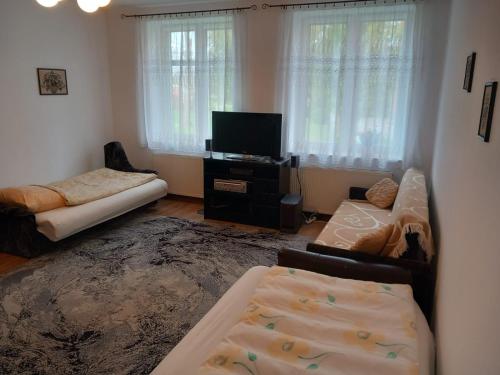 a living room with a couch and a flat screen tv at Kwatery pod wieżą in Pogrodzie