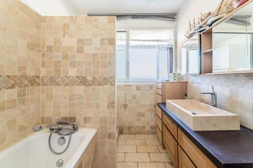 y baño con bañera y lavamanos. en Marseille: appartement standing vue sur mer, en Marsella