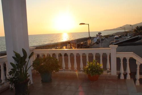 un balcón con macetas y el océano al atardecer en Sunset State Of Mind 1, en Néa Thésis