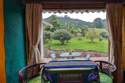 - une table et des chaises sur une terrasse couverte avec une fenêtre dans l'établissement Wepa la Pepa Campestre, à Tabio