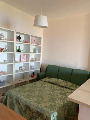 a living room with a green couch and shelves at Villa Stefania in Marina di Camerota
