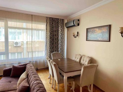een woonkamer met een tafel en een bank bij 3+1 ŞİŞLİ SQUARE CENTRAL HOUSE in Istanbul
