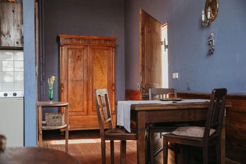 a kitchen with a table and chairs and a wooden cabinet at Schloss Schmarsow, Wohnung BLAU 