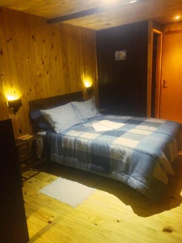 - une chambre avec un lit dans une pièce dotée de murs en bois dans l'établissement Bom Jardim Pousada, à Bom Jardim da Serra