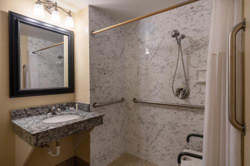 a bathroom with a sink and a shower at AmericInn by Wyndham Cedar Rapids North in Cedar Rapids