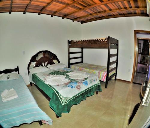 um quarto com 2 beliches e um sofá em Chácara Vale Verde em Camanducaia