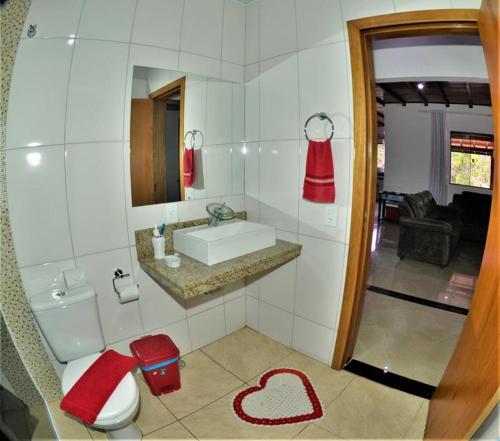 uma casa de banho com um WC e um lavatório com um coração no chão em Chácara Vale Verde em Camanducaia