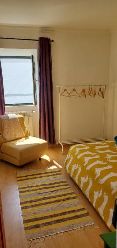 1 dormitorio con cama, ventana y alfombra en A casa da Laranjeira en Vale Covo