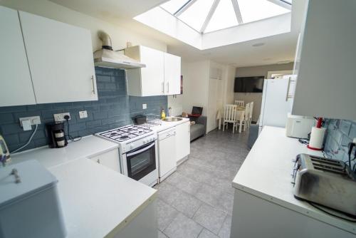 a kitchen with white appliances and a skylight at STAY SA Cosy equipped studios available 10 mins from the city! Free WIFI &50" SMART TV's! in Birmingham