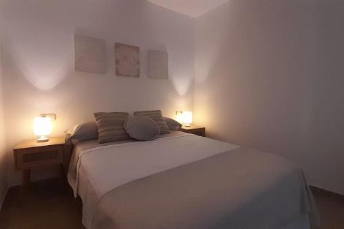 een slaapkamer met een bed en twee lampen op twee tafels bij Rinconcito en el almendral in Jaén