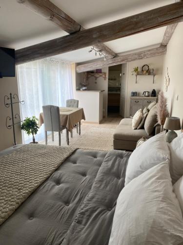 a bedroom with a large bed and a table at Les Gîtes de La Petite Campagne in Mane