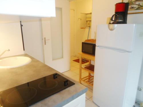 une cuisine avec un réfrigérateur blanc et un évier dans l'établissement Appartement 2 pièces climatisé, 300m plages, piscine, à Cavalaire-sur-Mer