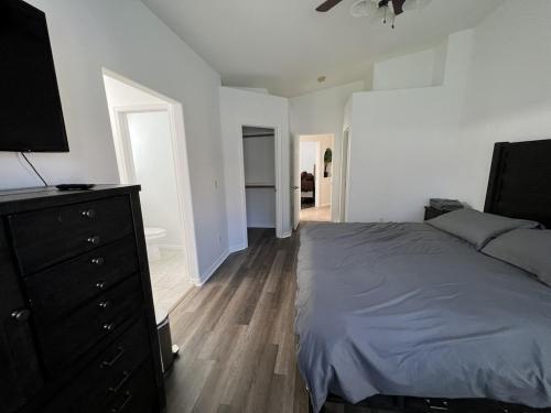 een slaapkamer met een bed en een dressoir met een televisie bij 3 Bedroom 2 Bath Oasis in Cozy Neighborhood in Las Vegas