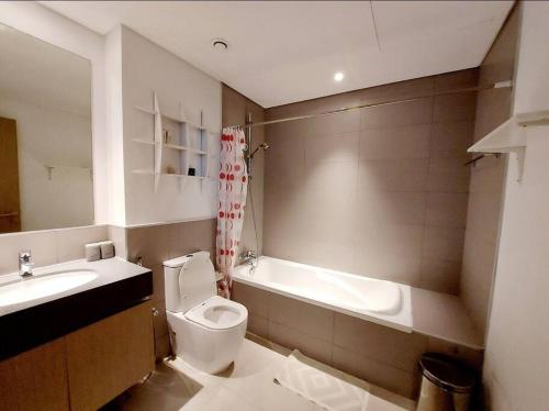 uma casa de banho com um lavatório, um WC e uma banheira em 1BR Warm and comfortable APT em Sharjah