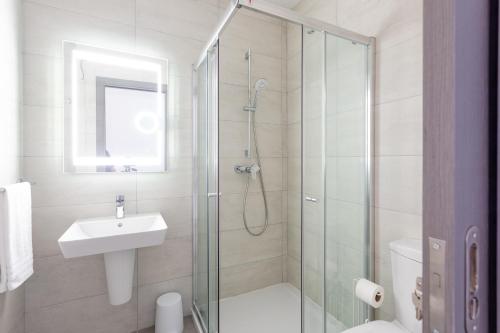 a bathroom with a shower and a toilet and a sink at Gospa 58 - 2 bedroom apt in Birżebbuġa