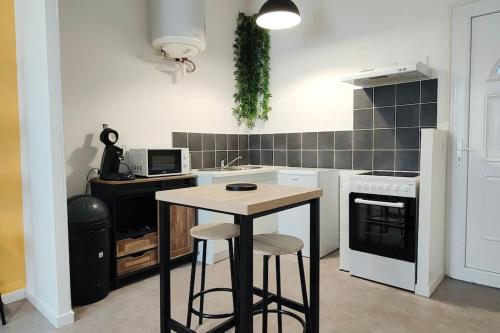 a kitchen with a table and a stove and a sink at Bel appartement face Citadelle in Blaye