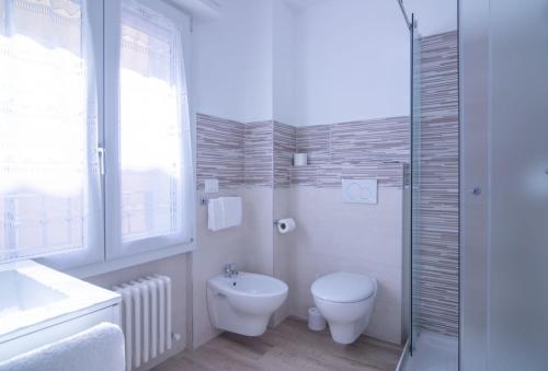 uma casa de banho branca com um WC e um lavatório em Affittacamere Ceccarini em Riccione