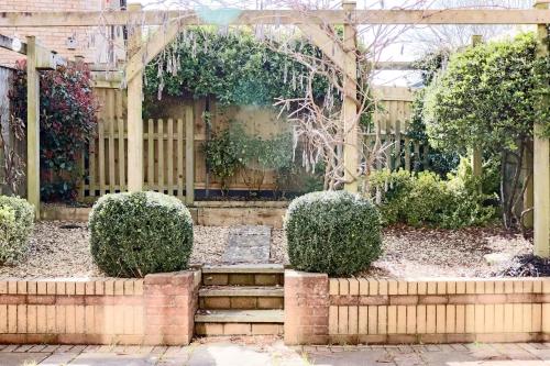 a garden with a wooden pergola and stairs at Wester-Moor comfy modern house in Barnstaple by StayStay com in Barnstaple