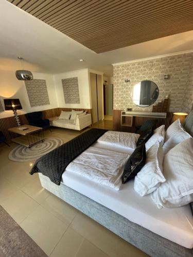 duża sypialnia z dużym łóżkiem z białą pościelą i poduszkami w obiekcie Avangard PRESTIGE w Świnoujściu