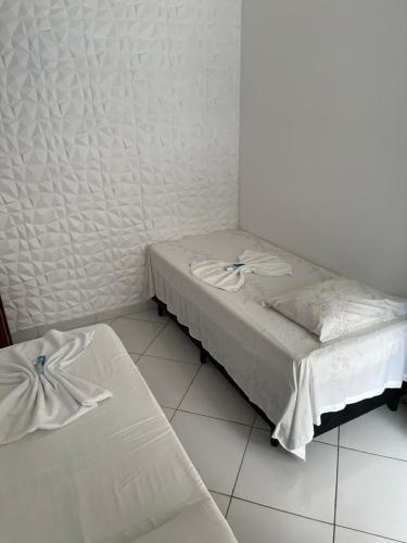 a small bedroom with a bed and a white floor at Pousada Canto Juquehy in Juquei
