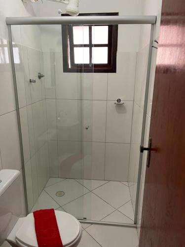 a bathroom with a glass shower with a toilet at Pousada Canto Juquehy in Juquei