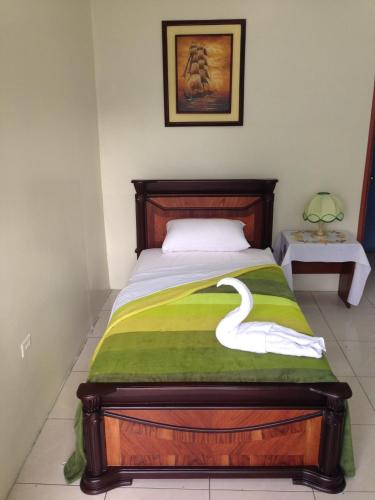 a bedroom with a bed with a swan on it at Hotel MundialCity in Guayaquil