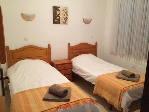 Dos camas en una habitación con dos sombreros. en Casa Anna, en Denia