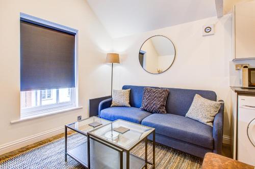 a living room with a blue couch and a table at Beautiful One Bedroom Apartment in Brentwood