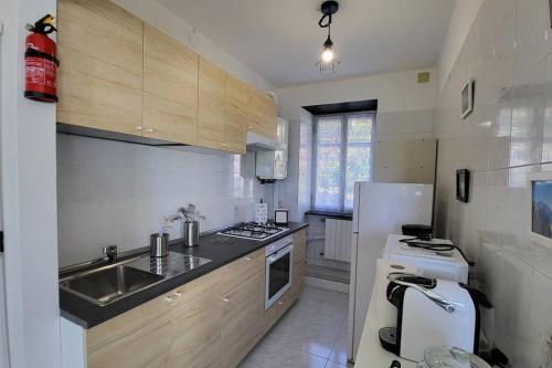 una pequeña cocina con fregadero y nevera. en La casa di Giada&Gaia, en Recco