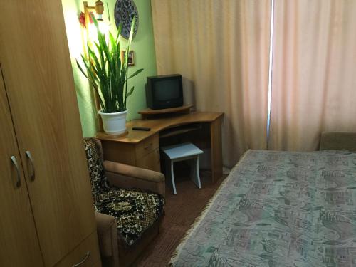 Zimmer mit einem Bett und einem Schreibtisch mit einem TV in der Unterkunft Бюджетные Комнаты посуточно 5мин McDonalds WI-FI 15мин до центра города in Ternopil