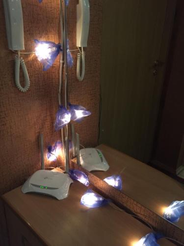 a bathroom with lights on a counter in front of a mirror at Бюджетные Комнаты посуточно 5мин McDonalds WI-FI 15мин до центра города in Ternopilʼ