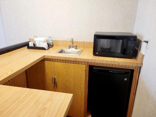 a kitchen with a microwave and a sink at Bangor Grande Hotel in Bangor
