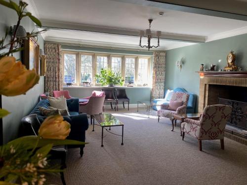 a living room with chairs and a fireplace at Plumber Manor Hotel in Sturminster Newton