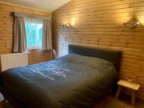um quarto com uma cama numa parede de madeira em Het Zenhuisje em Lanaken