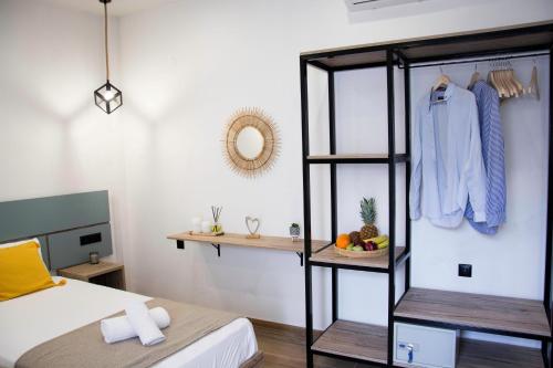 a room with a bed and a shelf with a clothes at Big Max Guesthouse in Kavos