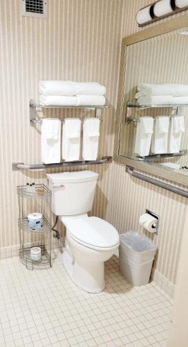 a bathroom with a toilet and a mirror and towels at Bangor Grande Hotel in Bangor
