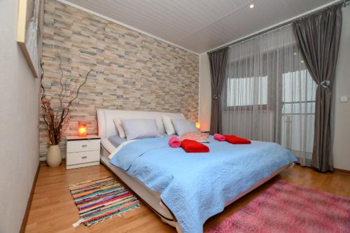 - une chambre avec un grand lit et un mur en briques dans l'établissement Apartment Camelia, à Poreč