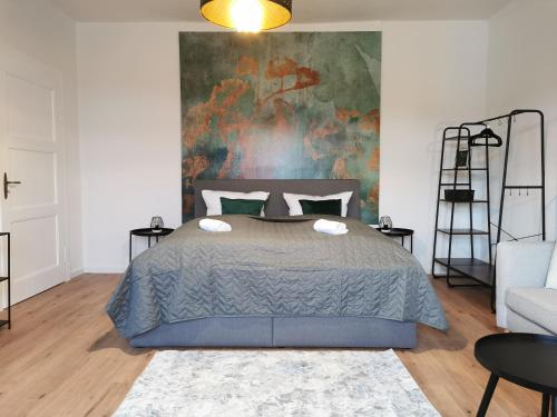 ein Schlafzimmer mit einem Bett und einem Wandgemälde in der Unterkunft BohnApartments EGA Stadtblick - Garten - WLAN - Nähe Theater EGA und Messe in Erfurt