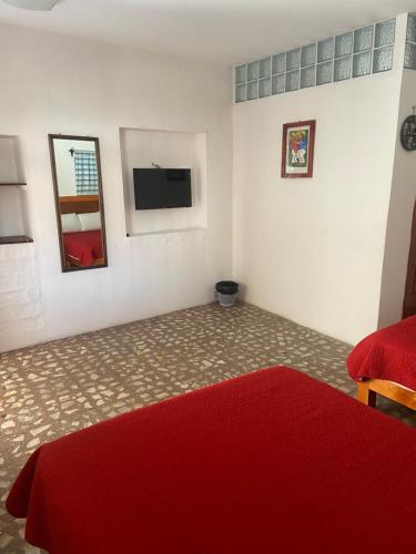 a bedroom with a red bed and a mirror at EL GRAN TORIL in Taxco de Alarcón