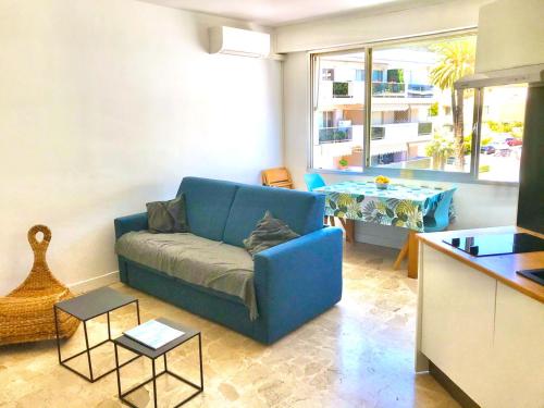 a living room with a blue couch and a table at Beaulieutiful City Center apartment in Beaulieu-sur-Mer